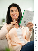 young beautiful woman doing crosswords in room. Стоковое фото, агентство Ingram Publishing / Фотобанк Лори