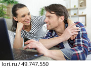 couple layed on the sofa looking at a laptop. Стоковое фото, агентство Ingram Publishing / Фотобанк Лори