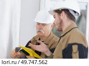 two men plastering wall with professional work tool. Стоковое фото, агентство Ingram Publishing / Фотобанк Лори