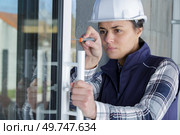 woman builder repairing window with screwdriver. Стоковое фото, агентство Ingram Publishing / Фотобанк Лори