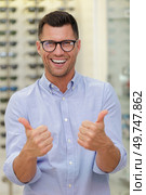 man with glasses and thumbs up at optics store. Стоковое фото, агентство Ingram Publishing / Фотобанк Лори