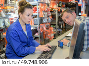 elegant brunette checking parts availability in a garage warehouse. Стоковое фото, агентство Ingram Publishing / Фотобанк Лори