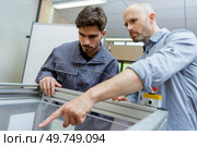 two careful workmen work at pvc windows factory. Стоковое фото, агентство Ingram Publishing / Фотобанк Лори