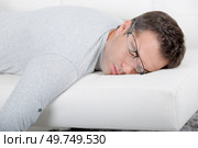 attractive man with glasses napping on the couch. Стоковое фото, агентство Ingram Publishing / Фотобанк Лори