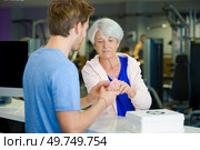 lady showing wrist injury to man in fitness-center. Стоковое фото, агентство Ingram Publishing / Фотобанк Лори