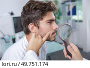 close-up of doctors hands checking mans moles. Стоковое фото, агентство Ingram Publishing / Фотобанк Лори