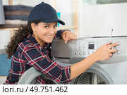 female technician fixes a washing machine leak in the kitchen. Стоковое фото, агентство Ingram Publishing / Фотобанк Лори