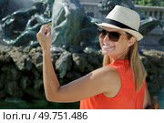 woman is holding a coin next to a fountain. Стоковое фото, агентство Ingram Publishing / Фотобанк Лори