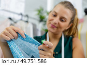 pretty woman cutting a pattern out of blue tissue. Стоковое фото, агентство Ingram Publishing / Фотобанк Лори