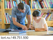male teacher working with college student in library. Стоковое фото, агентство Ingram Publishing / Фотобанк Лори