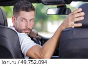 a man reversing a car. Стоковое фото, агентство Ingram Publishing / Фотобанк Лори