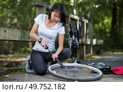 woman pumping on a bicycle wheel. Стоковое фото, агентство Ingram Publishing / Фотобанк Лори