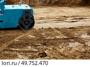 Construction site features a blue roller compacting earth on a freshly excavated ground during daylight hours. Стоковое фото, фотограф Виктория Тельминова / Фотобанк Лори
