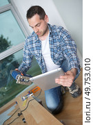 carpenter using a tablet to instal a laminate flooring. Стоковое фото, агентство Ingram Publishing / Фотобанк Лори