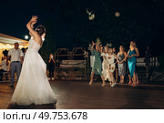 bride in a white dress throws a wedding bouquet to her unmarried girlfriends. Стоковое фото, агентство Ingram Publishing / Фотобанк Лори