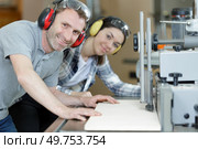 carpenter showing apprentice how to use sawing machine. Стоковое фото, агентство Ingram Publishing / Фотобанк Лори