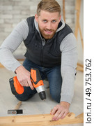carpenter using cordless screwdriver on piece of wood. Стоковое фото, агентство Ingram Publishing / Фотобанк Лори