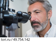 ophthalmologist examining womans eyes with modern equipment. Стоковое фото, агентство Ingram Publishing / Фотобанк Лори