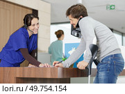 man on crutches signing in at hospital reception. Стоковое фото, агентство Ingram Publishing / Фотобанк Лори