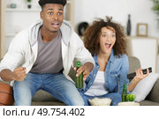 man watching americal football with his wife. Стоковое фото, агентство Ingram Publishing / Фотобанк Лори