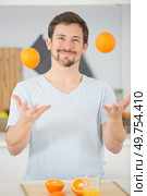 happy young man juggles with oranges. Стоковое фото, агентство Ingram Publishing / Фотобанк Лори