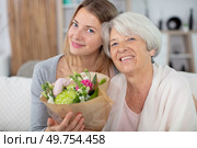 mother and daughter cuddling at home with flowers. Стоковое фото, агентство Ingram Publishing / Фотобанк Лори