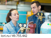 workers discussing next to oxygen cylinders. Стоковое фото, агентство Ingram Publishing / Фотобанк Лори