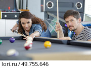 couple playing pool with woman taking aim. Стоковое фото, агентство Ingram Publishing / Фотобанк Лори
