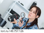female photographer checking camera with magnifying glass. Стоковое фото, агентство Ingram Publishing / Фотобанк Лори