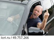 impudent man at the wheel shows an indecent gesture. Стоковое фото, агентство Ingram Publishing / Фотобанк Лори