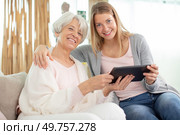 joyful smiling woman and her adult daughter using tablet. Стоковое фото, агентство Ingram Publishing / Фотобанк Лори