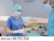 Nurse holding syringe, patient face down on bed. Стоковое фото, агентство Ingram Publishing / Фотобанк Лори