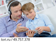 Dad and son wearing headphones. Стоковое фото, агентство Ingram Publishing / Фотобанк Лори
