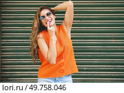 Cute latin woman with sunglasses flirting with the camera in an urban space. Cute woman with sunglasses flirting with the camera. Стоковое фото, агентство Ingram Publishing / Фотобанк Лори