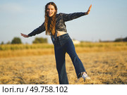 In a vibrant golden field, a joyful young woman dances with exuberance, embodying the spirit of freedom and happiness as she moves gracefully beneath the vast expanse of a clear blue sky. A Joyful Young Woman Dancing Freely in a Golden Field During a Beautiful Sunset Hour. Стоковое фото, агентство Ingram Publishing / Фотобанк Лори