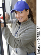 happy female worker screwing window. Стоковое фото, агентство Ingram Publishing / Фотобанк Лори