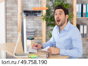 businessman looks in wonder at dangling carrot above him. Стоковое фото, агентство Ingram Publishing / Фотобанк Лори