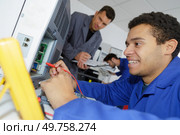 happy apprentice fixing a calibrated device. Стоковое фото, агентство Ingram Publishing / Фотобанк Лори