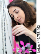 woman looking at necklace accessory. Стоковое фото, агентство Ingram Publishing / Фотобанк Лори