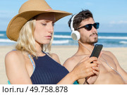 couple using their phones on the beach. Стоковое фото, агентство Ingram Publishing / Фотобанк Лори