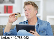 man holds tablet and credit card in his hands. Стоковое фото, агентство Ingram Publishing / Фотобанк Лори