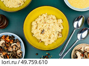 Traditional Ukrainian millet porridge with mushrooms in a ceramic dish. Top view.. Pearl millet with fried mushrooms. Стоковое фото, агентство Ingram Publishing / Фотобанк Лори