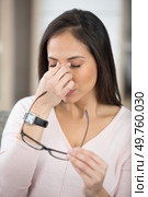 woman holding spectacles and rubbing the bridge of her nose. Стоковое фото, агентство Ingram Publishing / Фотобанк Лори