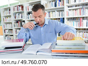 a busy man in the library. Стоковое фото, агентство Ingram Publishing / Фотобанк Лори