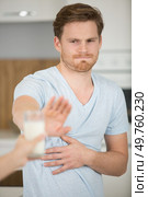man refusing glass of milk offered by person. Стоковое фото, агентство Ingram Publishing / Фотобанк Лори