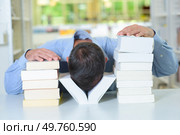 Man with his head between two piles of books. Стоковое фото, агентство Ingram Publishing / Фотобанк Лори