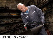 senior blacksmith forging metal on the anvil. Стоковое фото, агентство Ingram Publishing / Фотобанк Лори