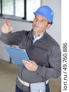 engineer man wearing helmet holding clipboard pointing. Стоковое фото, агентство Ingram Publishing / Фотобанк Лори