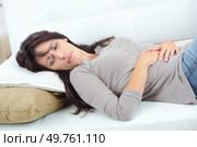 Lady layed on sofa with stomach ache. Стоковое фото, агентство Ingram Publishing / Фотобанк Лори
