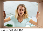 disappointed millennial female client open post shipping package. Стоковое фото, агентство Ingram Publishing / Фотобанк Лори
